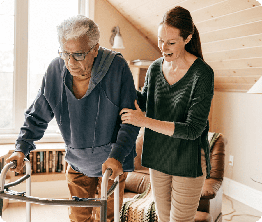 Caregiver assisting elderly man with walker